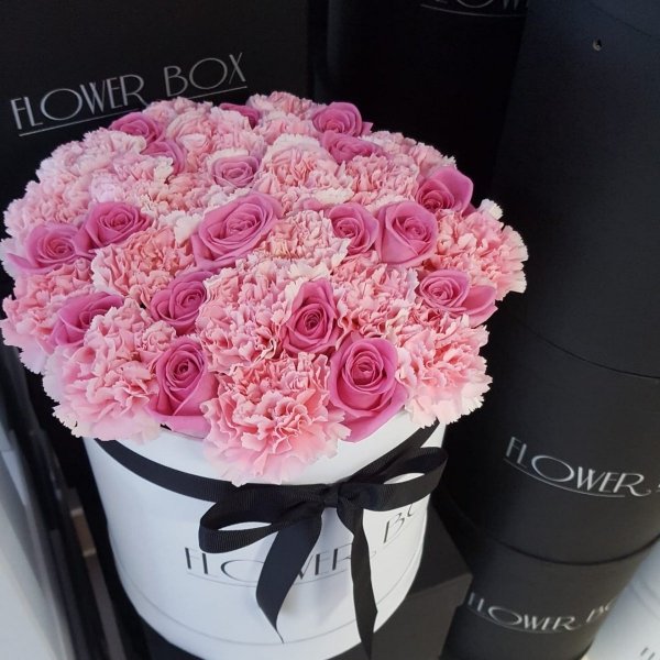 Mix różowych żywych róż z goździkami w dużym białym boxie