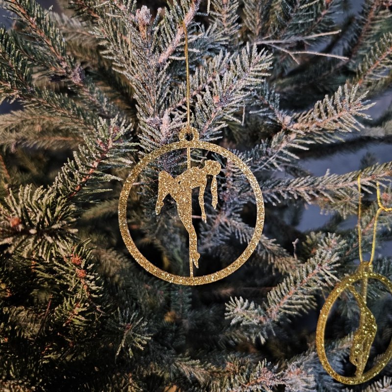 Close-up of the shining Gold Glitter Pole Dance Ornament on a tree branch with lights
