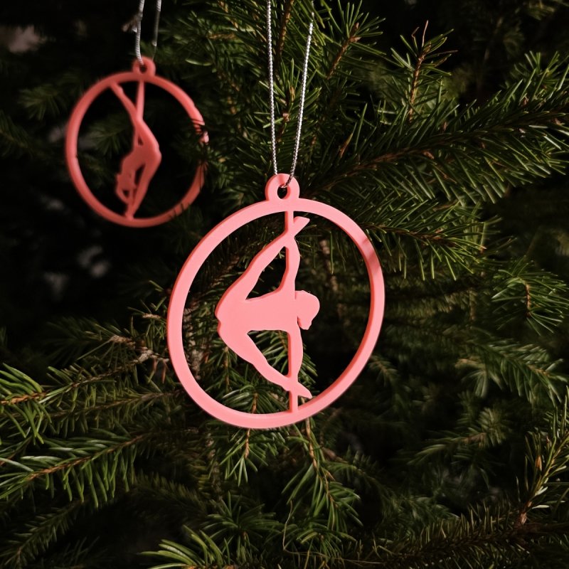 Close-up of a Pink Glow in the Dark Pole Dance Ornament on a decorated Christmas tree branch. Amira Perun Xmas Decor