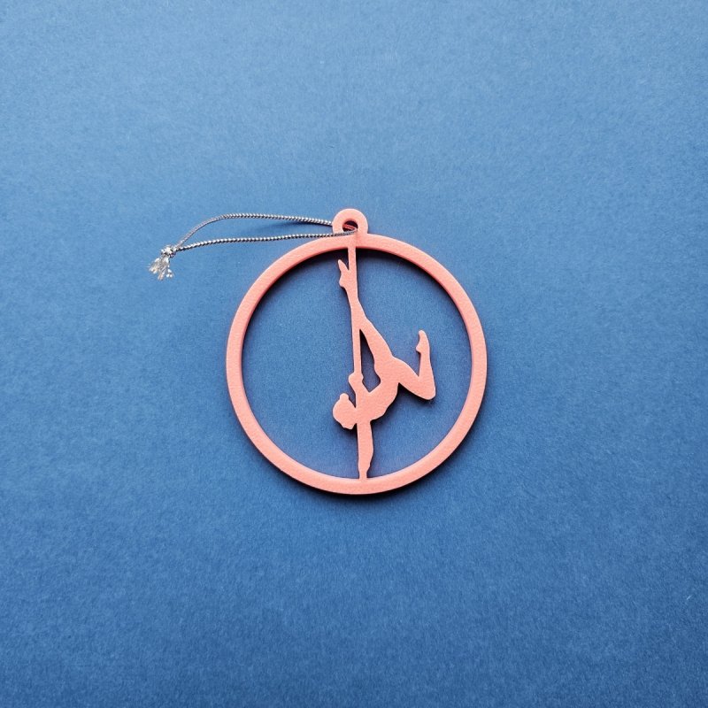 Pink Glow in the Dark Pole Dance Ornament (Pose A) on a blue background. Unique Poledance Christmas Decor
