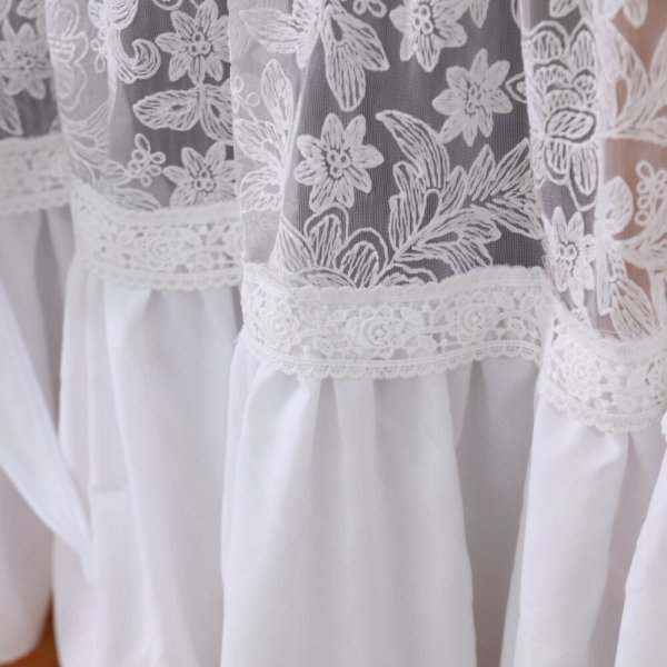 Zbliżenie na fakturę tkaniny haftowanej i koronkowej wstążki łączącej materiały w modelu Ida.