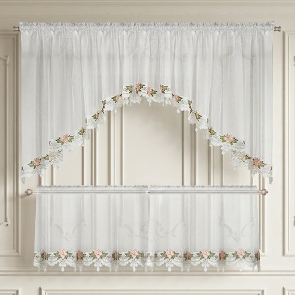 Widok na białą firanę woalową w oknie, pokazujący jak materiał przepuszcza naturalne światło dzienne.