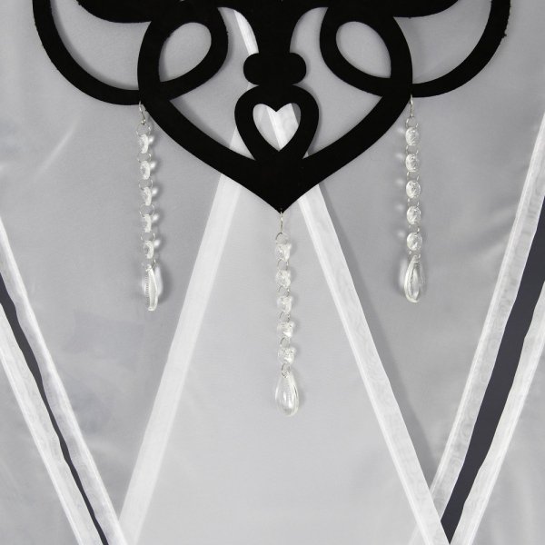 Zbliżenie na fakturę białego woalu połączonego z czarnym elementem ażurowym i ozdobnymi koralikami.